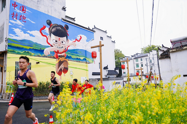 “村跑”活动中，来自全国各自的跑步爱好者们正在穿越油菜花田。农业部农村社会事业促进司供图