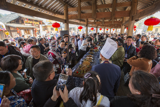 在湖南省保靖县的“村字号”活动中，来自全国各地的游客争相品尝当地美食。农业部农村社会事业促进司供图
