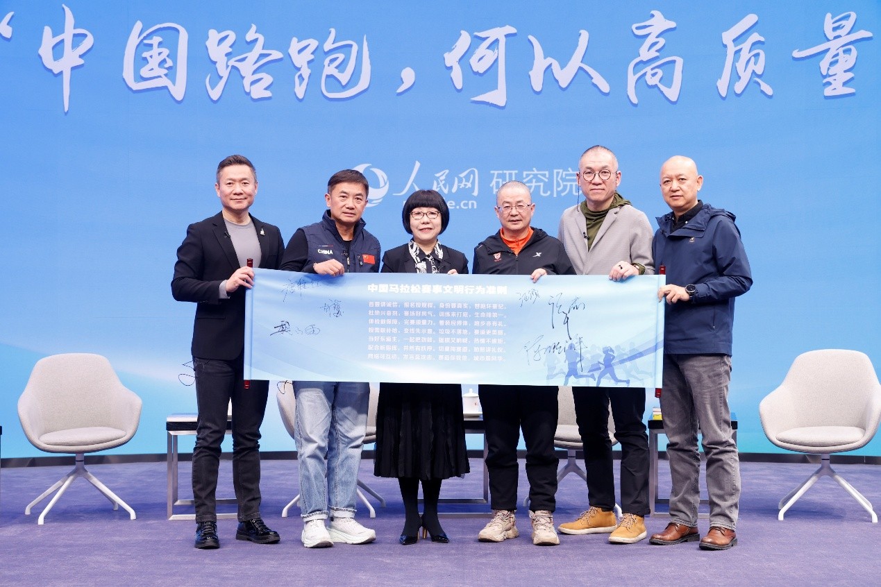 嘉宾在《中国马拉松赛事文明行为准则》上签名后留影