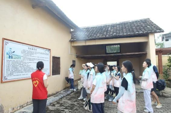 图3：讲解员向成员们介绍韦纯束故居